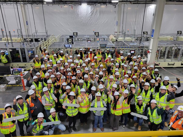 얼티엄셀즈 직원들이 제2공장에서 생산된 첫 배터리를 들고 기념사진을 찍고 있다. 사진=LG에너지솔루션 제공